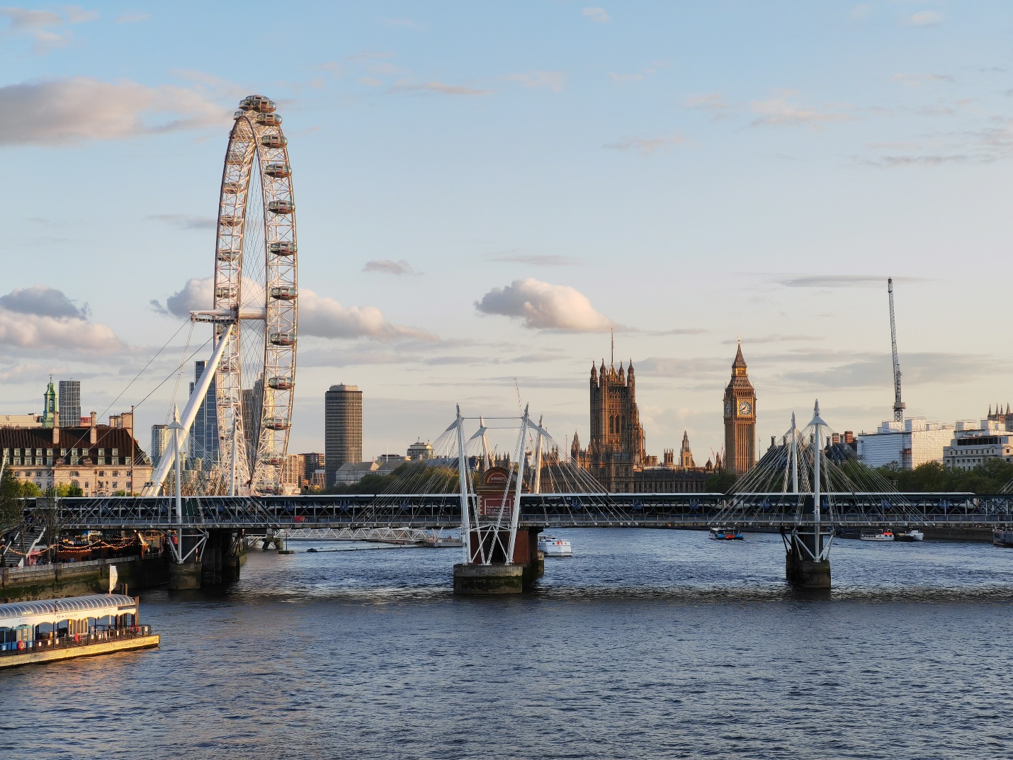 A bridge over a river with a ferris wheel

Description automatically generated